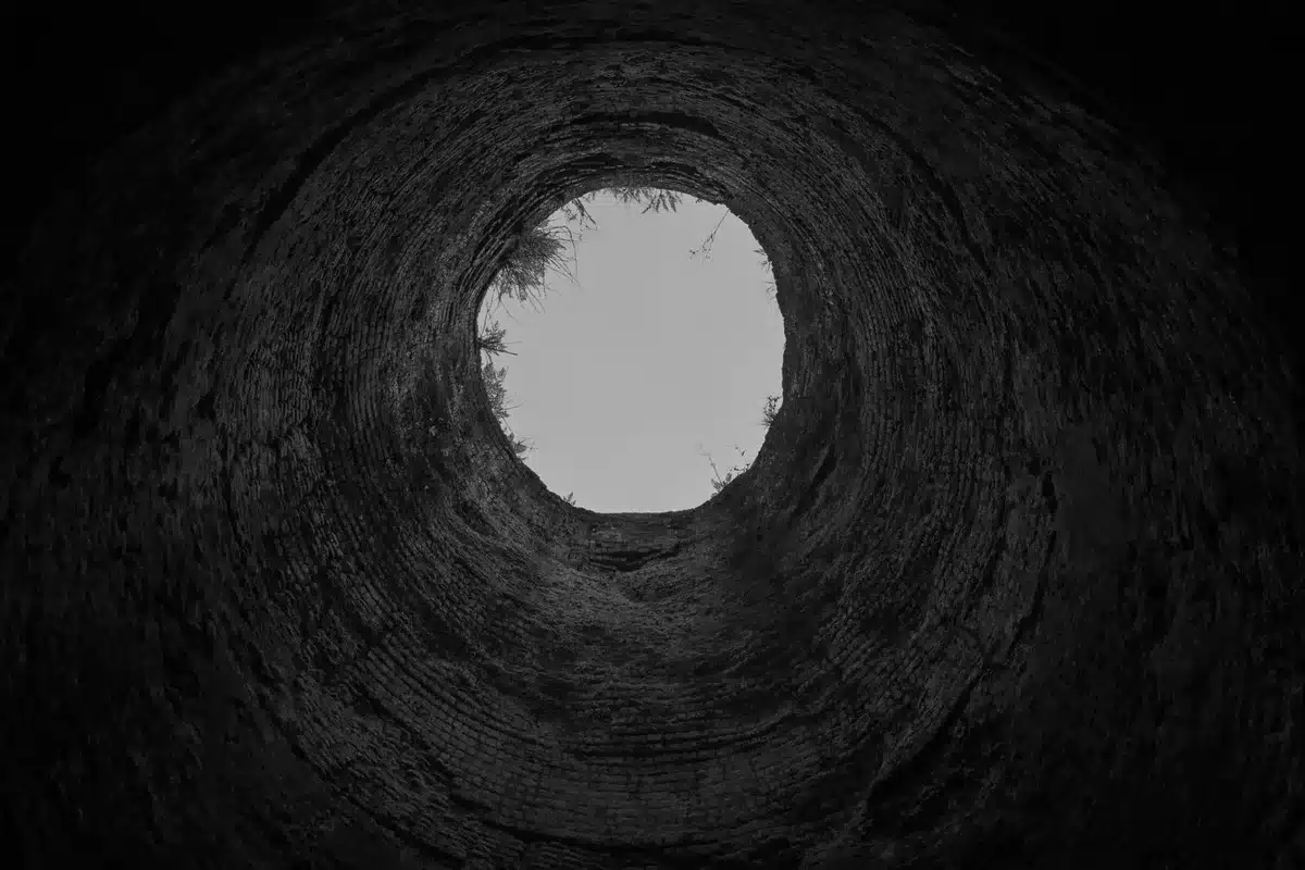 Scavo di un pozzo profondo con rivestimento di ciottoli nel sito archeologico di Kainua