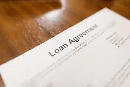Documento di autorizzazione bancaria con timbro di approvazione su scrivania con grafici finanziari