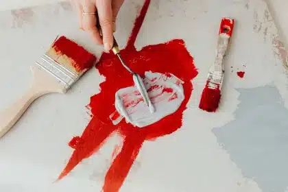 Studio di artista con tela, pennelli e pigmenti colorati su superficie di lavoro illuminata da luce naturale