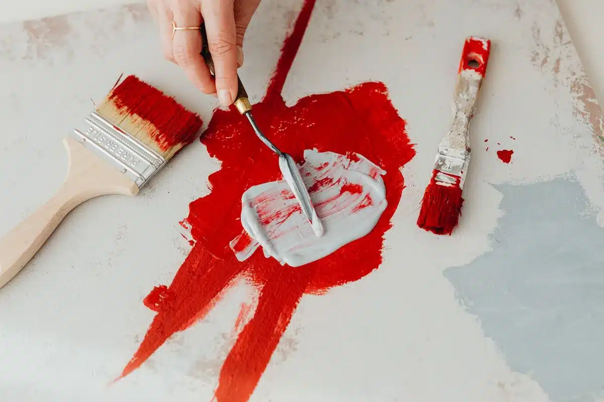 Studio di artista con tela, pennelli e pigmenti colorati su superficie di lavoro illuminata da luce naturale