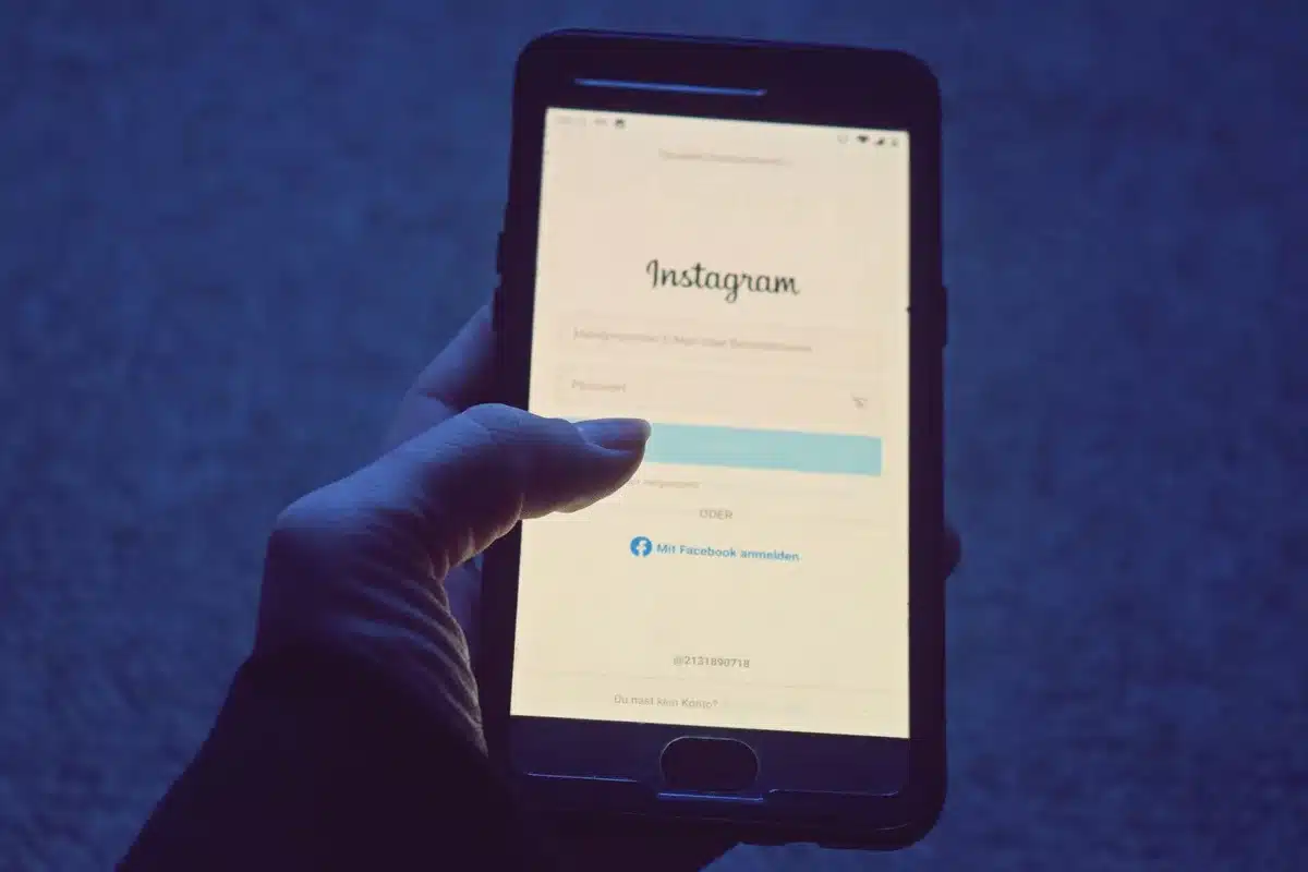 Mano di una persona anonima contro lo schermo di uno smartphone illuminato al buio, simboleggiando la censura algoritmic