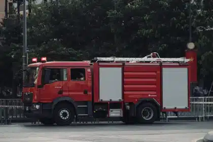 Magazzino in fiamme con vigili del fuoco e mezzi d'emergenza in intervento notturno