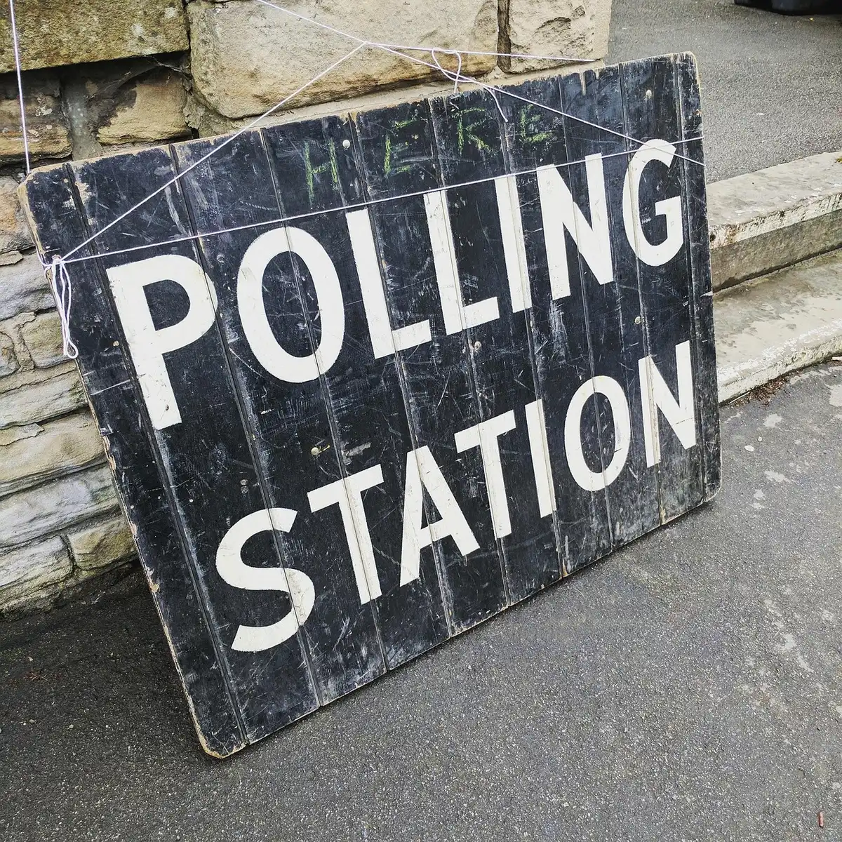 Seggio elettorale con urna e schede per le primarie democratiche