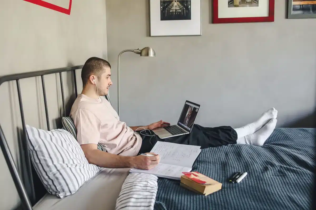 Studente che studia in una camera, lontano da casa per motivi di studio