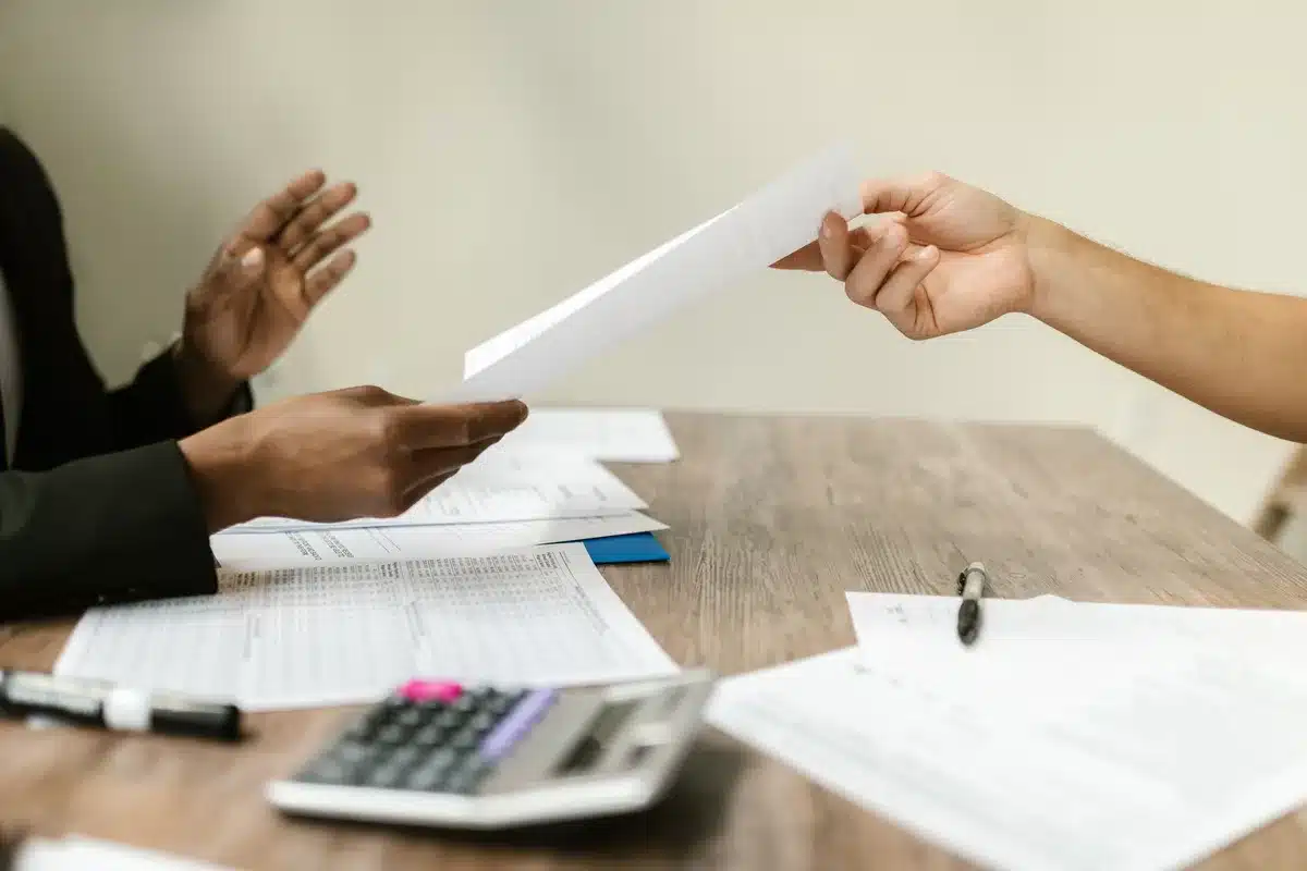 Documenti amministrativi e pratiche su una scrivania d'ufficio con computer