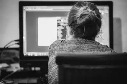 Computer anonimi su tavolo di coworking con lucchetto che evoca chiusura dei servizi