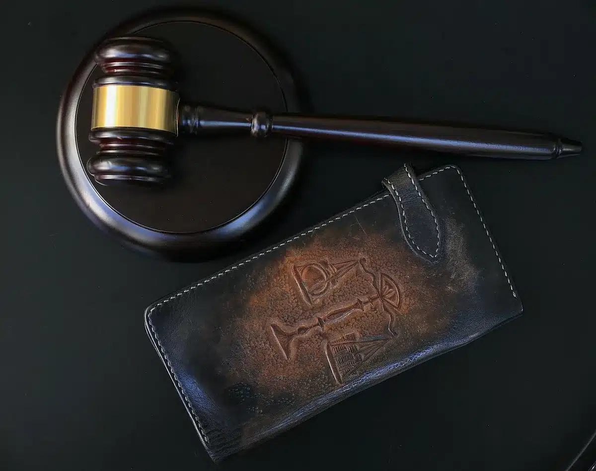 Aula di tribunale con documenti legali e figure anonime durante procedimento giudiziario