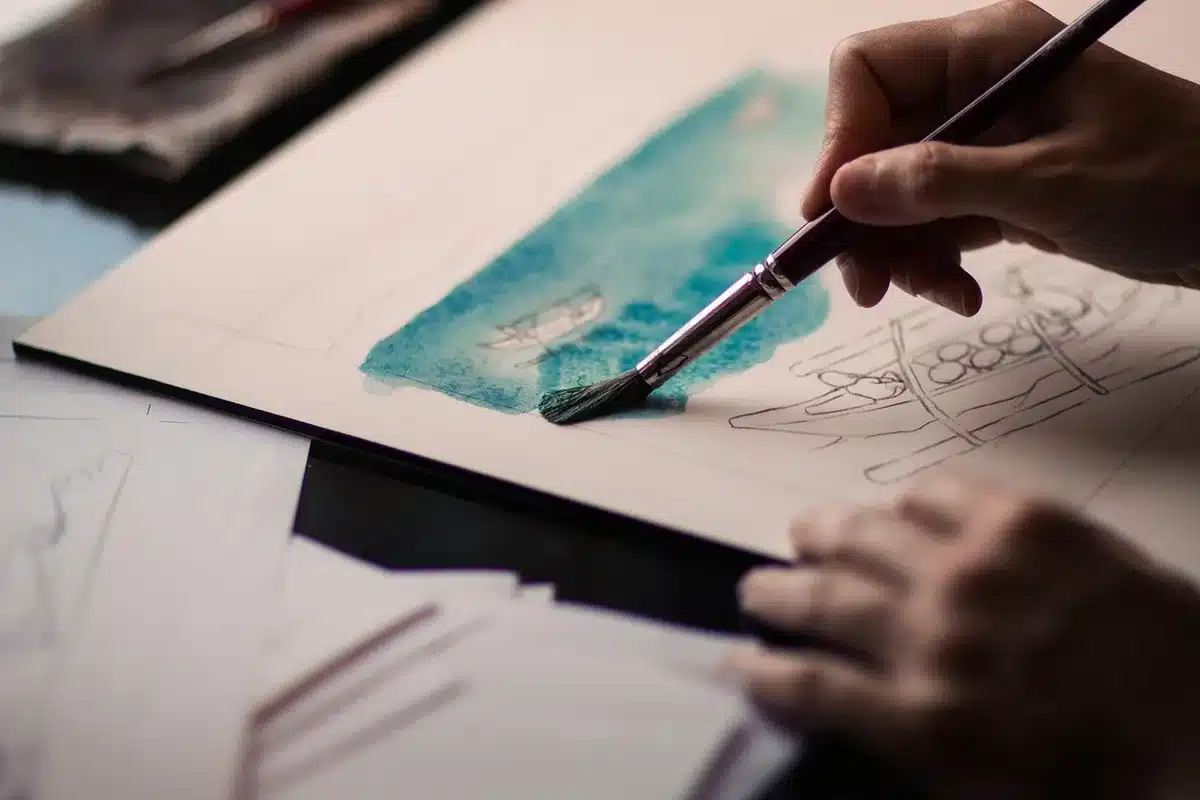 Studio con artista di spalle davanti a un quadro con forme astratte e colori naturali