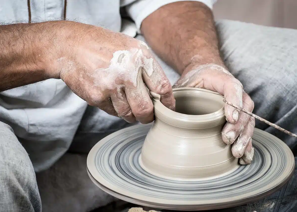 Mani accanto a uno schermo che mostra immagini digitali e superfici in ceramica