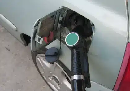 Mano che tiene il tubo della pompa di benzina a una stazione di servizio