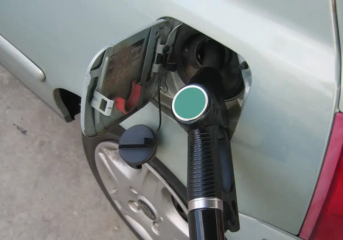 Mano che tiene il tubo della pompa di benzina a una stazione di servizio