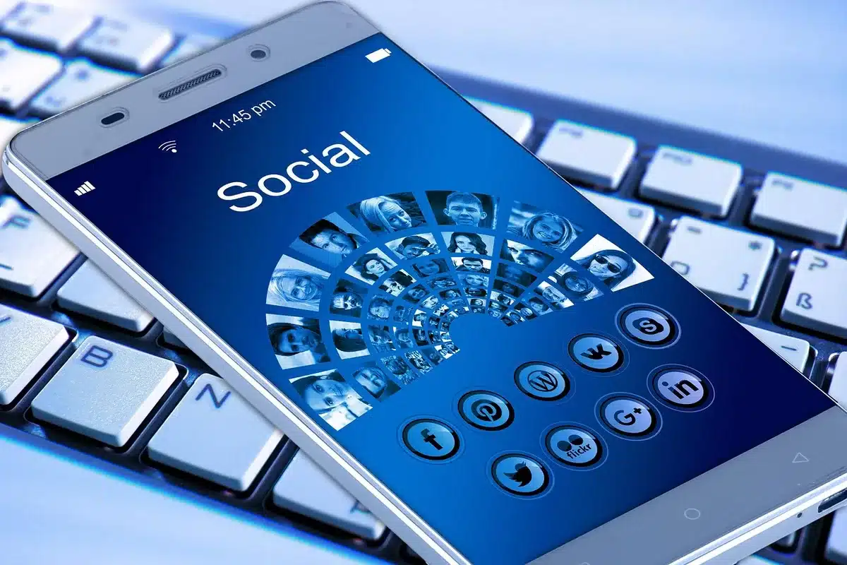 Mani che tengono uno smartphone con notifiche e feed di social media sullo schermo