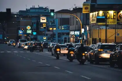 Strada urbana di notte con silhouette, lampioni e un'ambulanza in lontananza