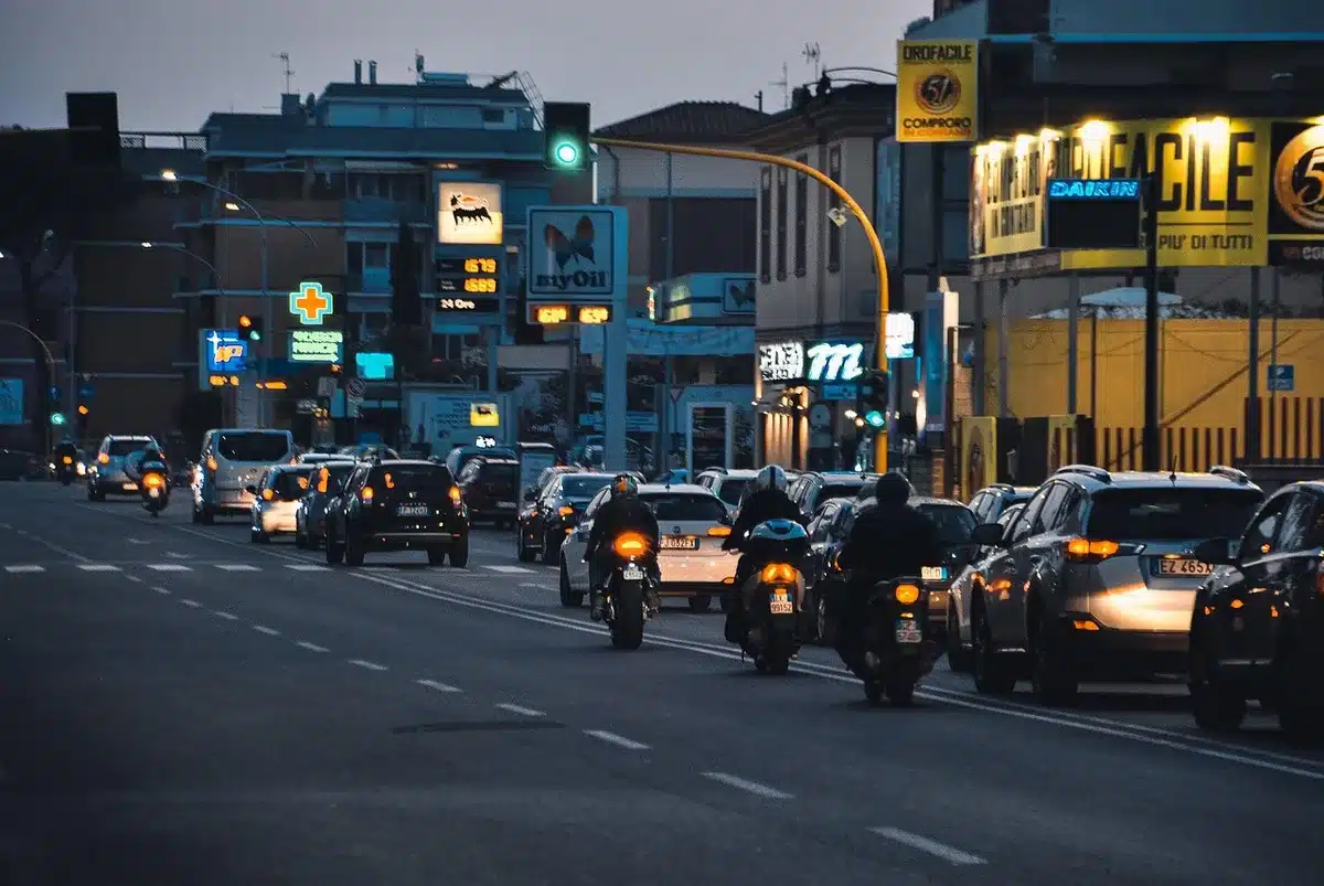 Strada urbana di notte con silhouette, lampioni e un'ambulanza in lontananza