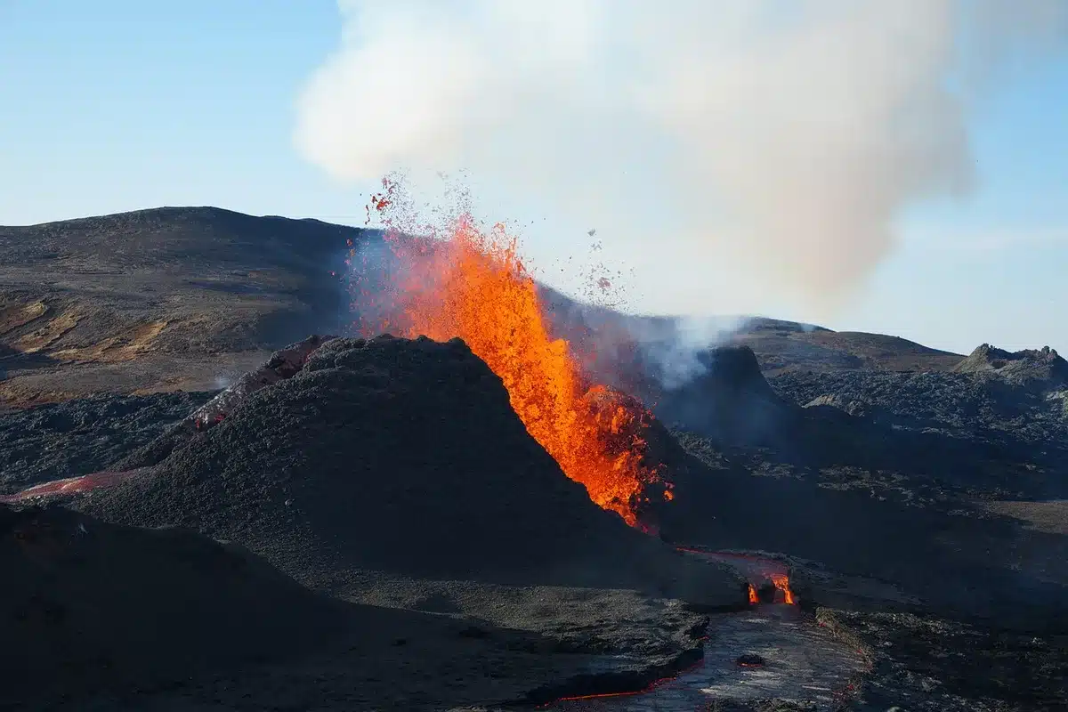 Cartello generico di zona interdetta vicino a vulcano, silhouette di persone in lontananza