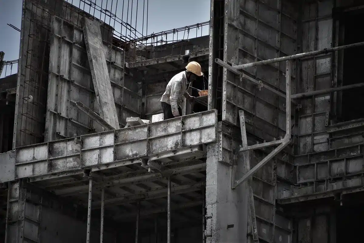 Cantiere di edilizia sociale incompleto con strutture vuote e gru