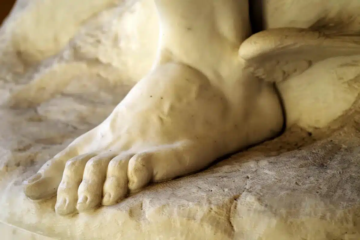 Visitatori che toccano e si siedono su sculture in marmo
