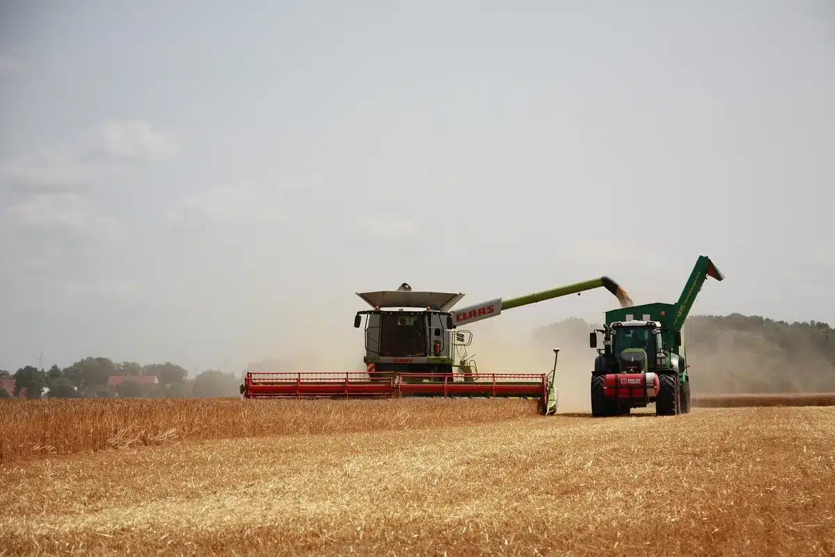 Campo agricolo in declino con macchinario fermo e terreno coltivato ridotto