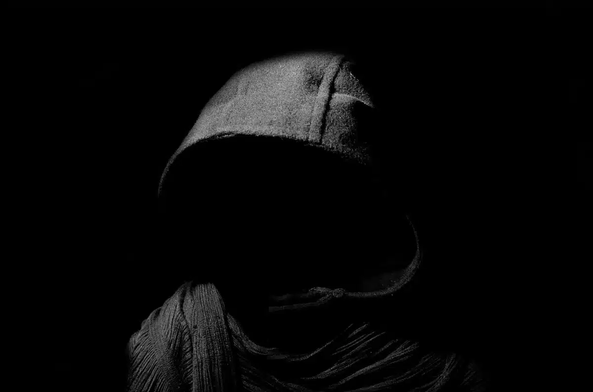 Due figure anonime silhouette di profilo sedute a un tavolo, scena che evoca confronto politico