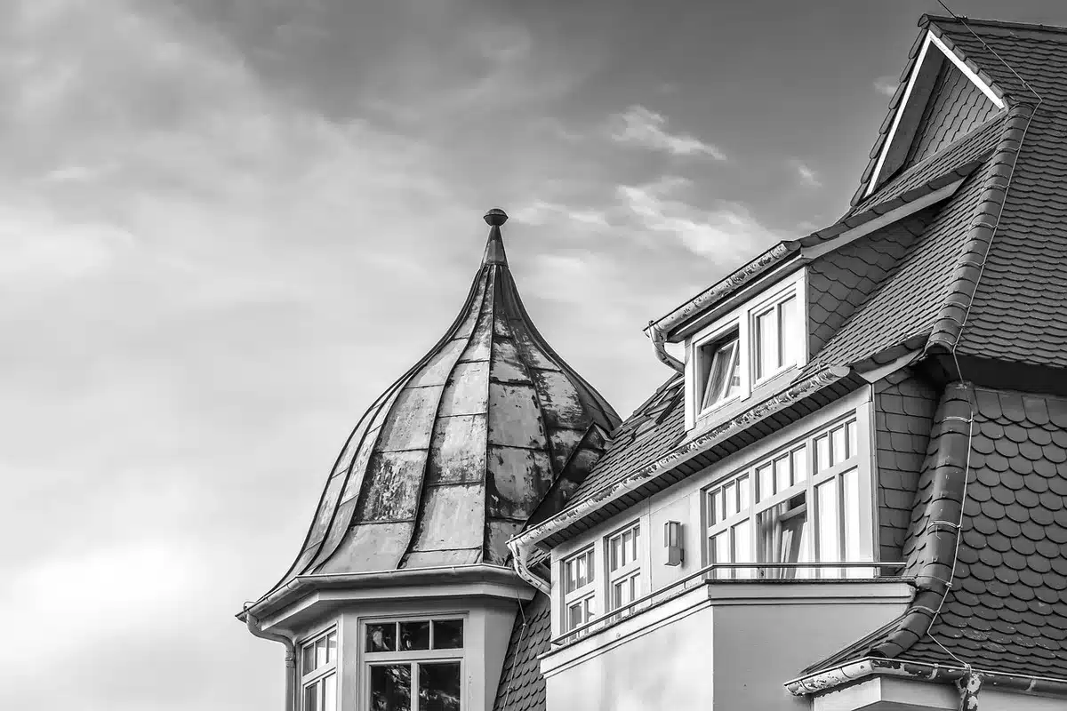 Silhouette di mani che scambiano documenti davanti a un edificio istituzionale