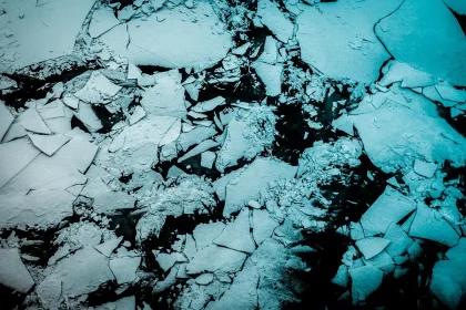 Plateau antartico con una stazione scientifica anonima e una nave vicino all'orizzonte