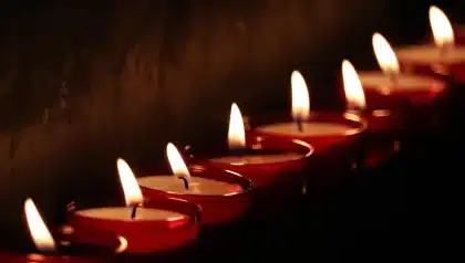 Folla anonima con candele e fiori in memoria, all'esterno di una sinagoga
