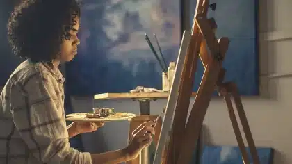 Laboratorio d'artista con pannelli, bombolette spray e materiali ceramici in primo piano