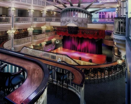 Palcoscenico illuminato con sedili vuoti e atmosfera teatrale