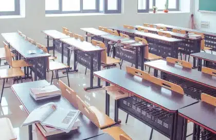 Tavolo con rapporti economici e un podio vuoto, figura anonima di spalle